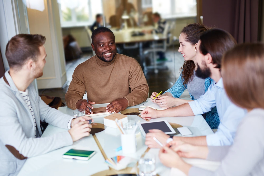 A Leader Conducting A Meeting, Illustrating The Contrast In Leadership Impact Between Supervisor Vs Manager