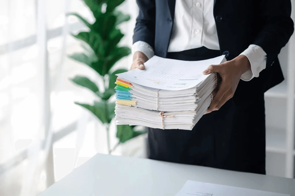 A Recruiter Holding A Stack Of Applicant Documents Knows The Pile Includes Candidates For Positions That Do Not Require Background Checks