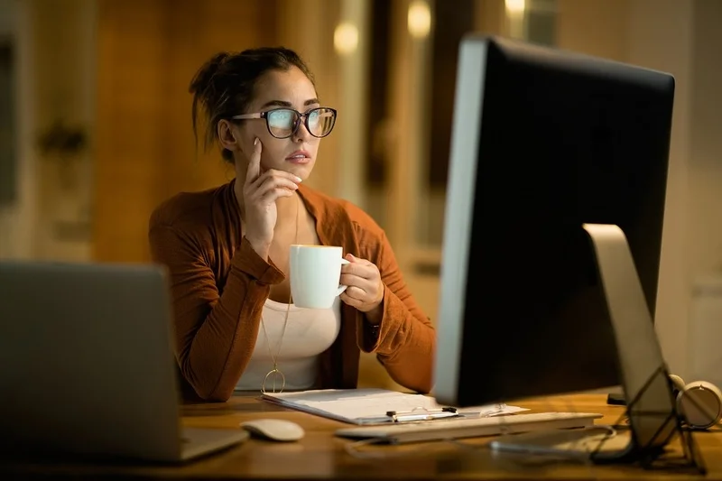 A Woman Is Reading A Guide On How To Respond To An Interview Request While Drinking A Coffee