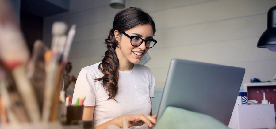 Woman smiling at laptop — Job descriptions to attract millennials
